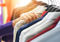 Close-up of hand on rack of assorted professional clothing
