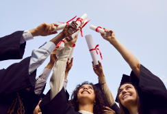 College graduates holding up diplomas